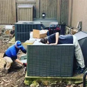 HVAC Maintenance Tumbling Shoals, AR - Preventative Plans 2 HVAC technician inspecting a thermostat and electrical connections during a tune-up service